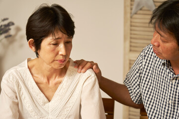 家で落ち込む中年女性