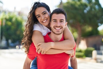Fototapeta premium Young hispanic couple smiling confident hugging each other holding on back at street