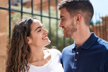 Fototapeta premium Young hispanic couple smiling confident hugging each other at street