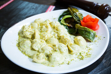 Cappelletti pasta stuffed with meet cooked with sauce and mushrooms. Traditional Italian recipe.