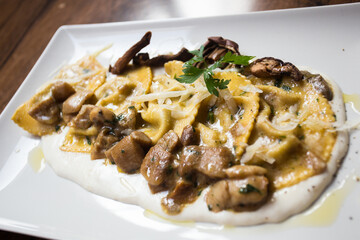 Agnolotti pasta stuffed with meet cooked with sauce and mushrooms. Traditional Italian recipe.