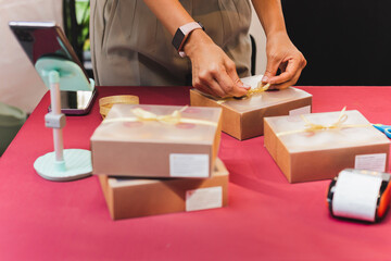 Woman small business owner packing box on table delivery to customer.