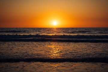 Beautiful sunset over the sea. Rays of the sun touches surface of the calm sea. Meditative atmosphere.