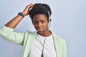 African american woman wearing call center agent headset confuse and wondering about question. uncertain with doubt, thinking with hand on head. pensive concept.