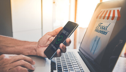 Man using computer purchase food online and pay. Smartphone in hand. Home delivery, catering concept