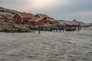Beautiful little typical red swedish house in a long exposure directly at the sea. PORT in a bay by...