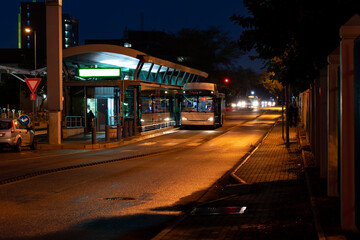 Bus parked at a bus stop at night