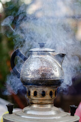  Iron teapot on smoke coal fire in the samovar outside