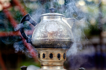 Vintage weathered charcoal burning samovar, preparing tea party outside 