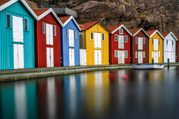 Beautiful little colorful fishermen's houses at the harbor. Typical Swedish houses in a long...