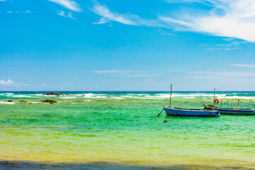 Fototapeta premium Boats on the waters of the paradisiacal beach of Itapua in the city of Salvador in Bahia