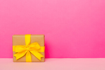 holiday paper present tied yellow ribbon bow top view with copy space. Flat lay holiday background. Birthday or christmas present. Christmas gift box concept with copy space