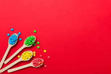 delicious colorful sweet candies on spoon on colored background . Confectionery decor top view with...