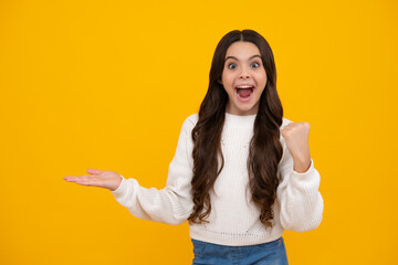 Excited teenager girl. Teenager child pointing to the side with a finger to present a product or idea. Teen girl in casual outfit pointing empty space.