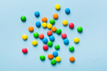Mixed collection of colorful candy, on colored background. Flat lay, top view. frame of colorful chocolate coated candy