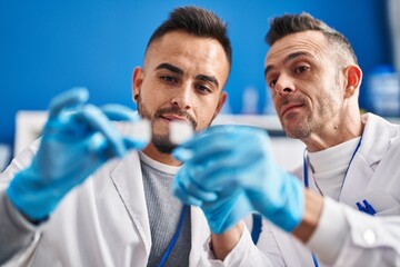 Two men scientists looking sample at street