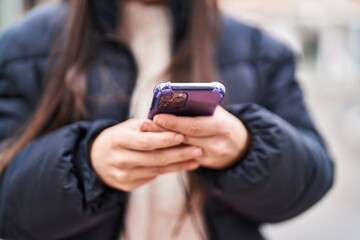 Young beautiful hispanic woman using smartphone at street