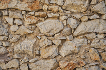 Rough stone wall, laying the foundation of an old house or foundation of a structure, idea for a background or wallpaper
