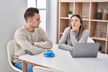 Man and woman couple stressed sitting on table at home