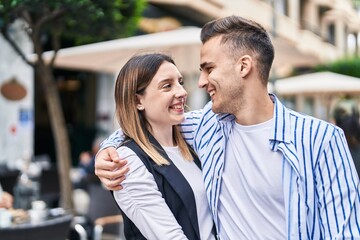 Man and woman couple smiling confident hugging each other at street