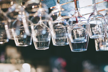 Empty glass for wine over bar shelf, bokeh lights background.