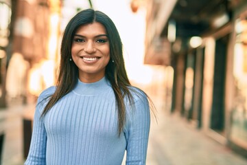 Beautiful hispanic woman smiling confient at the city