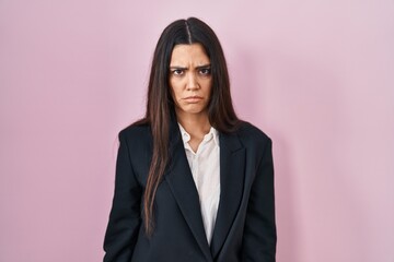 Young brunette woman wearing business style over pink background skeptic and nervous, frowning upset because of problem. negative person.
