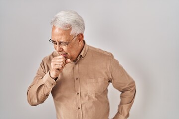 Hispanic senior man wearing glasses feeling unwell and coughing as symptom for cold or bronchitis. health care concept.