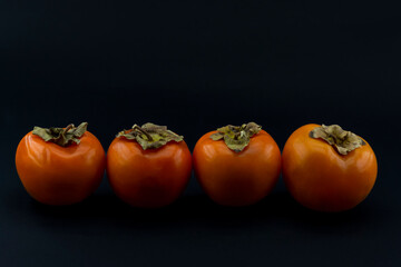 Natural and Organic Kaki fruit (Turkish: persimmon) on black background
