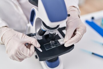 Young woman scientist using microscope working at laboratory