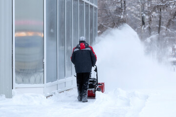 A portable snow blower powered by gasoline. Snow removal in winter.