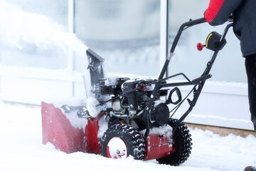 A portable snow blower powered by gasoline. Snow removal in winter.