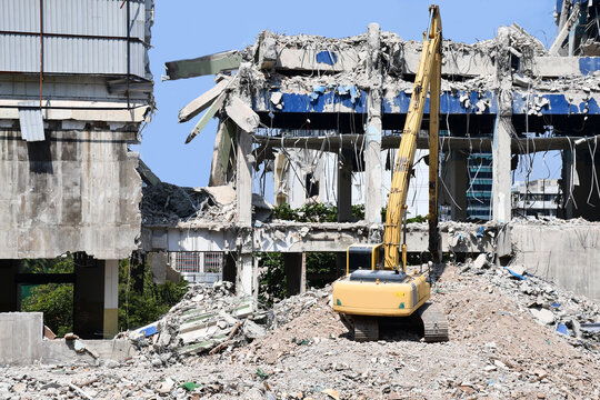 Building demolition, Backhoe excavator and truck clearing wreckage, Concept image for demolish or remove a building, Construction site and contractor.