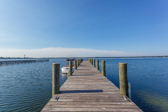 Dock leading out to a large blue lake with a clear blue sky above