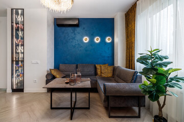 A modern living room interior of a luxurious hotel apartment with a designer couch, and art...