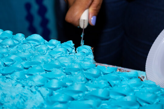 Cutting cake with blue frosting. birthday cake.