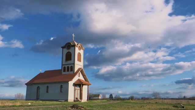 Time lapse of a cute lovely little church in the middle of a field on a cloudy and sunny day