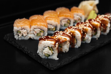 Sushi on a stone plate with black background