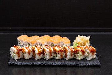 Sushi on a stone plate with black background