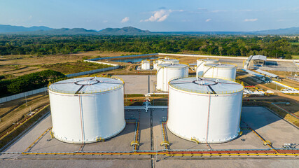 Aerial view white oil storage fuel tanks at depot station, White Industrial tanks for gasoline petrol and oil fuel with pipeline, Oil and gas industrial, Oil refinery plant industry.