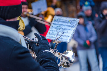 Close-up view on a trumpet player playing Christmas carols at Christmas time.