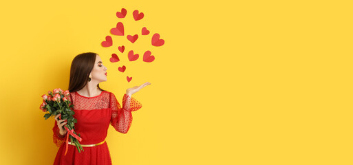Beautiful young woman with flowers and red hearts on yellow background with space for text. Valentine's Day celebration