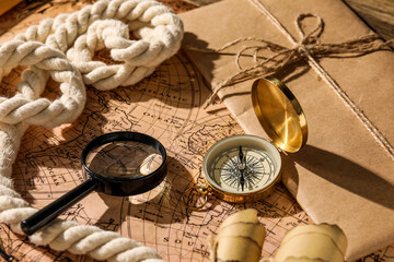 Fototapeta na wymiar Golden compass, magnifier and envelope on world map