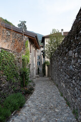 Lecco, Italy - April, 29, 2022: Very narrow streets between buildings in Italian mountain. Medieval village of Corenno Plinio.