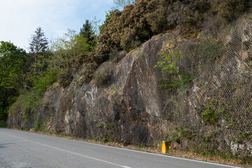 Protective wire mesh against falling rocks. Protection or caution on mountain road. Safety net for...