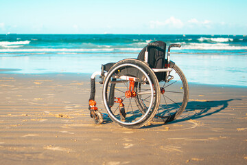 Photograph of a wheelchair on the beach, bringing a reflection