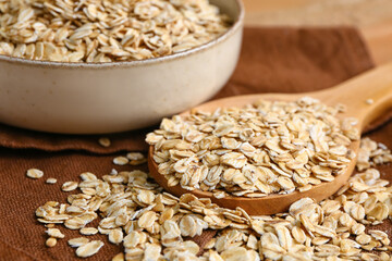 Wooden spoon with raw oatmeal, closeup