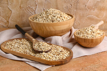 Plate and bowls with raw oatmeal on color table