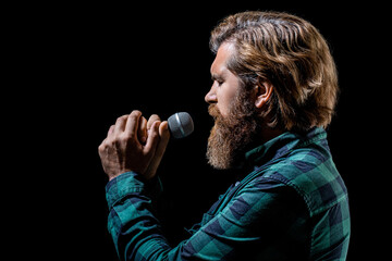 Bearded man singing with microphone. Male singing with a microphones. Man with a beard holding a...