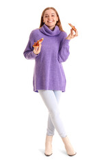 Fototapeta premium Beautiful young woman eating fresh pizza on white background